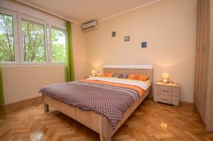 a bedroom with a bed and two windows at Apartment Nikolic Kotor in Kotor