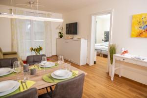 a dining room and living room with a table and chairs at Cityapartment Dornbirn 50 qm in Dornbirn