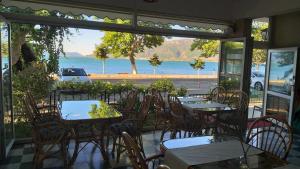 埃利迪尔GÖL PENSION Adult Only 16 Plus的一间有桌椅、可欣赏海景的餐厅