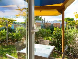 a patio with a table and chairs and an umbrella at Camping Lacona Pineta in Capoliveri