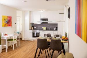 cocina y comedor con mesa y sillas en Cityapartment Dornbirn 50 qm, en Dornbirn