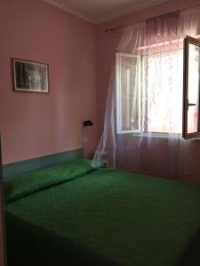 a bedroom with a green bed and a window at Villa Carla in Vieste