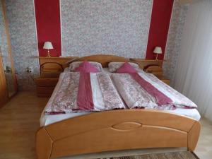 a bedroom with a wooden bed with pink sheets at Haus Alexandra in Schöneberg