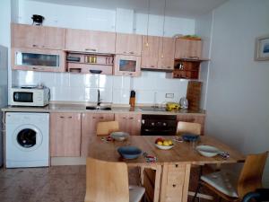 a small kitchen with a wooden table and a sink at Luna in Isla Plana