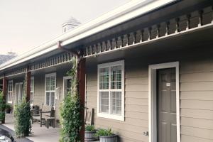 a house with black siding and a porch with plants at Wine Country Inn in Jacksonville