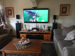 a living room with a flat screen tv on the wall at After8 B&B in Kleinbaai