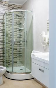 W łazience znajduje się szklana kabina prysznicowa, toaleta i umywalka. w obiekcie Friday Hotel w mieście Năvodari