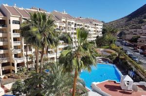 a view of a resort with a swimming pool and palm trees at Studio Castle Harbour vistas piscina in Los Cristianos