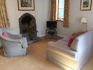 salon z 2 krzesłami i kominkiem w obiekcie Jock Scott Cottage w mieście Dunkeld