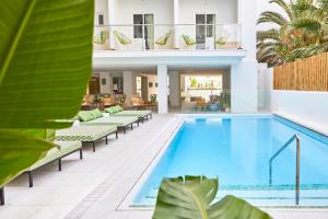 - une piscine avec chaises longues et une maison dans l'établissement HM Dunas Blancas, à Playa de Palma