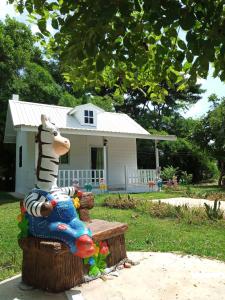 a toy zebra sitting on a bench in front of a house at Benjamat Resort in Sakon Nakhon