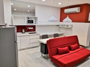 a red couch in a kitchen with a counter at Strait Garden Studio X Ace Pro @ George Town in George Town