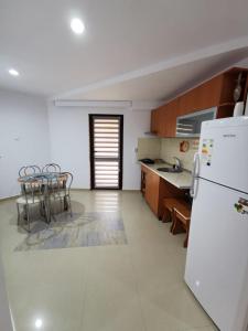 a kitchen with a refrigerator and a table and chairs at Apartament Catia in Călimăneşti