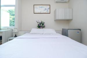 a bedroom with a large white bed with flowers on it at Blossom Resident Blok M in Jakarta