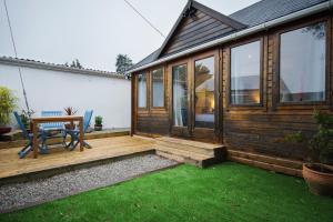 a wooden deck with a bench and a house at The cabin in Truro