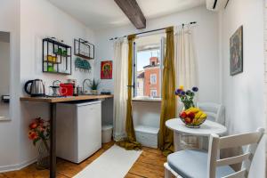 a small kitchen with a table and a chair at El Atico in Rovinj