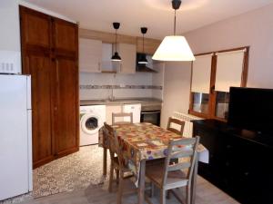 a kitchen with a table and chairs and a laundry room at Casa Cardelina in Camporrells