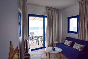 パラリオ・アストロスにあるMuses seaside Villasの青いソファとテーブルのあるリビングルーム