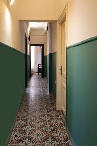 an empty hallway with green walls and a tile floor at Athens Market Portrait in Athens