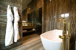 a bathroom with a bath tub and a sink at Vila Foz Hotel & SPA - member of Design Hotels in Porto