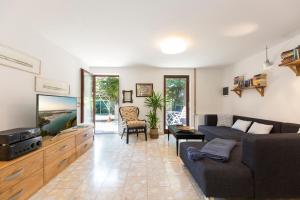 a living room with a couch and a tv at Casa Flora 3-minutes’ walk from the beach in Novigrad Istria