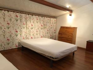 um quarto com uma cama e um papel de parede com flores em Appartement dans la résidence LES MAZETS DE CAMARGUE em Arles