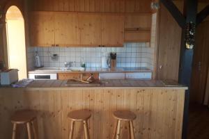 una cucina con 3 sgabelli e bancone di LUMA a Thyon-Les Collons
