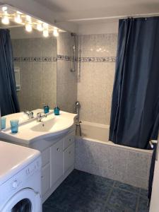 a bathroom with a sink and a washing machine at Appartement dans la résidence LES MAZETS DE CAMARGUE in Arles