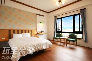 - une chambre avec un lit, un bureau et une fenêtre dans l'établissement Do Tian Ding B&B, à Lugu
