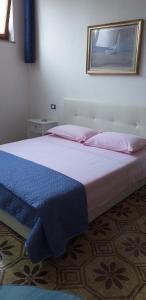 una camera da letto con un grande letto con lenzuola rosa e blu di la casa del pittore Anna house a Lerici