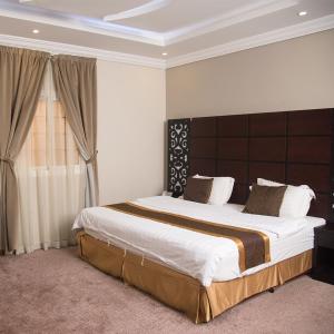 a large bed in a bedroom with a large window at City Center Plaza Aparthotel in Jeddah