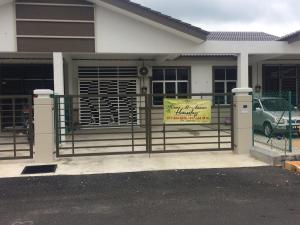 une maison dotée d'un portail avec un panneau. dans l'établissement Hanz Homestay Melaka - For Malay Only, à Malacca