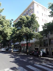 ヴェローナにあるCasa Corinnaの木々が並ぶ街路の大きな白い建物