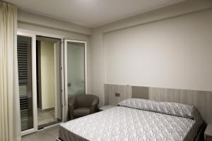 a bedroom with a bed and a chair at Residence 3 Oblò in Giulianova +44 photos
