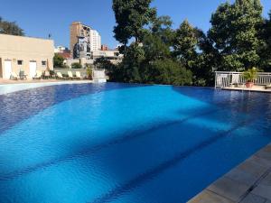 una gran piscina de agua azul en Apartamento Resort Morumbi, en São Paulo