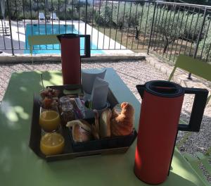 ein Tablett mit Brot und Orangensaft auf dem Tisch in der Unterkunft Le Clos en Provence in Flayosc