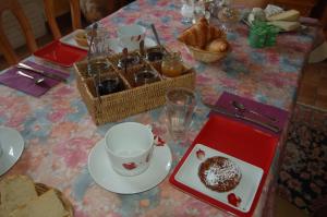 een tafel met een bord brood en een kopje koffie en een gebakje bij Chambres d'Hôtes Les Coquelicots in Francueil