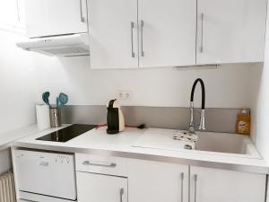 a kitchen with white cabinets and a sink at Gite chez LiLi in Ostheim