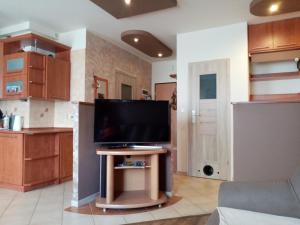Una sala de estar con un televisor de pantalla plana sobre una mesa. en Apartament na Kawiarach, en Gniezno