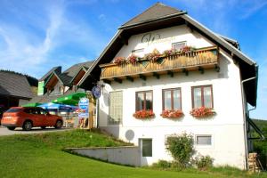 a white building with flowers on the balcony at Genussgasthof Willenshofer in Sankt Kathrein am Hauenstein