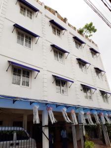 a large white building with blue accents at Queens Park Apartments in Colombo