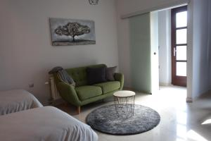 a living room with a green couch and a table at Studio apartmani Vinica in Vinica