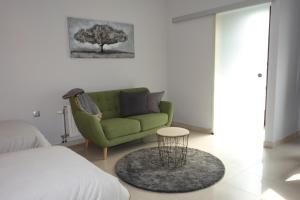 uma sala de estar com um sofá verde e uma mesa em Studio apartmani Vinica em Vinica