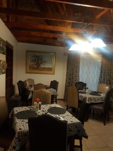 a dining room with tables and chairs and a room with tables and tablesktop at Sekelbos Guesthouse in Pretoria
