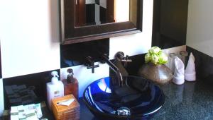 a bathroom counter with a blue sink and a mirror at La Rivière d' Angkor Resort in Siem Reap
