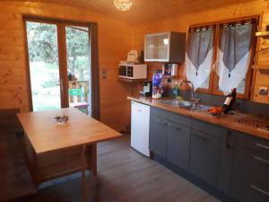 cocina con encimera de madera y mesa de madera en roulotte en Cournonterral