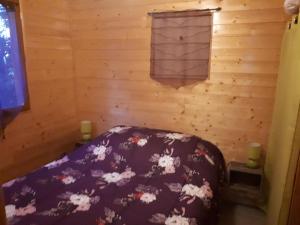 ein Schlafzimmer mit einem Bett in einem Holzzimmer in der Unterkunft roulotte in Cournonterral