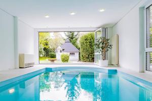 a swimming pool in a house with a large window at Dreamapartment La Vigna "Stone" Suite mit eigenem Indoorpool & Sauna & Grillhütte - Weil am Rhein in Weil am Rhein