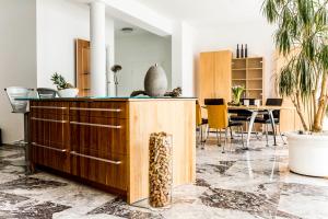 a living room with a table with chairs and a cabinet at Dreamapartment La Vigna "Stone" Suite mit eigenem Indoorpool & Sauna & Grillhütte - Weil am Rhein in Weil am Rhein