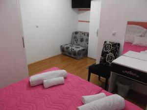 a room with a pink bed with two pillows on it at Prenociste Bojan 017 in Vranje